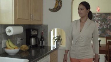 Kadın mutfakta bir bardak su alma.