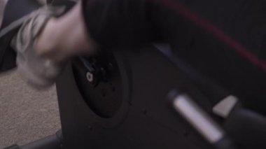 Spor salonunda sabit bir bisiklet kullanan bir kadının kaydırma eğimli çekim.