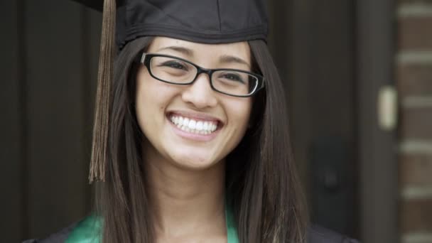 当有人拍照时 一个穿着毕业帽和礼服的年轻女子被拍到 — 图库视频影像
