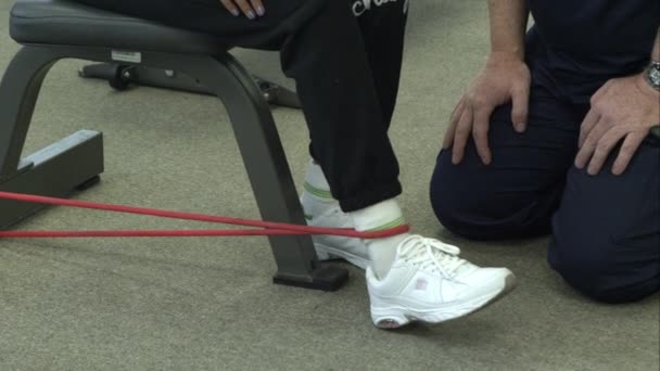 Tight Shot Therapist Working Teenage Girl Elastic Band Leg Exercise — Stock Video