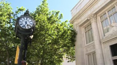 Şehir saati ve sokaktan bina.