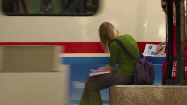 Circa 2017 - Salt Lake City, Utah: Sarışın kadının saçları okurken ve trafik geçerken rüzgarda esiyor. Sonra şehir tramvayına balıyor..