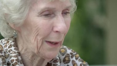 Yaşlı bir bayanın gülümseyen yüzünün sıkı görüntüsü.