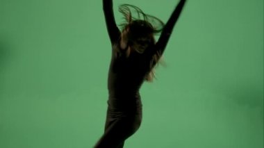 Yeşil ekranda arkadan aydınlatmalı kadın dans.