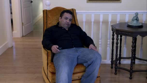 坐在扶手椅上的男子看着电视 站着评估自己的体重 — 图库视频影像