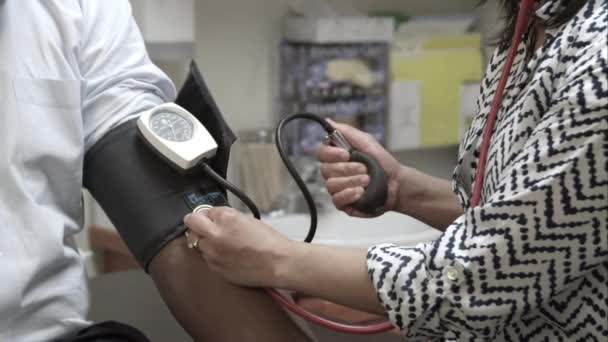 Bir Adam Bir Kan Basıncı Okuma Alarak Bir Doktorun Sıkı — Stok video