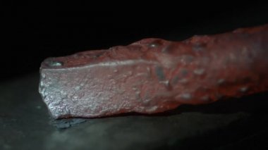 Metal parçaları uçarken yavaş çekimde dövülen kırmızı sıcak metal parçası.