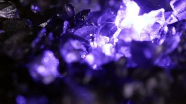 Dönen küçük kayalardan parlayan mor parıltı