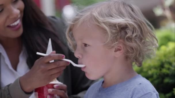 年轻女子给男孩喂食一勺充满能量运动的冰淇淋 — 图库视频影像
