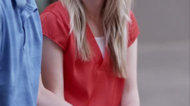 Birbirleriyle konuşurken el ele tutuşan genç çift.