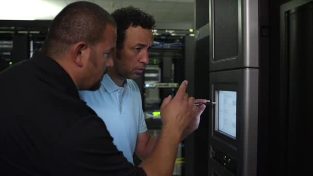 Twee Mannen Aan Het Werk Monitor Serverruimte Bespreken Wat Aan — Stockvideo