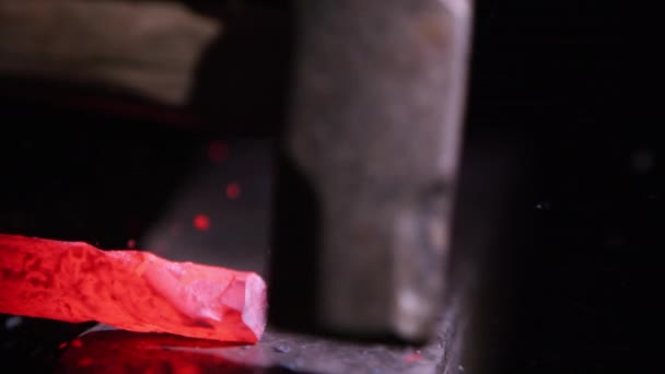 Rouge métal chaud étant martelé sur enclume de près 