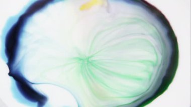 Beyaz sıvıda karıştırılan renklerin yavaş hareketi