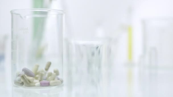 Schwenkblick Auf Pille Die Auf Glasbehälter Fällt — Stockvideo