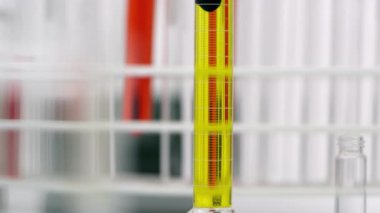 Test tüpünde sarı sıvı ile karıştırma koyu sıvı yavaş tava.