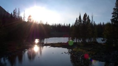 Uinta Dağları'nda gölet üzerinde güneşe doğru uçan.