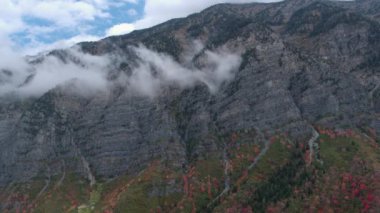Renkli yeşillik ile alçak bulutlar dağ uçurumlarda arasında kaydırma havadan görünümü.