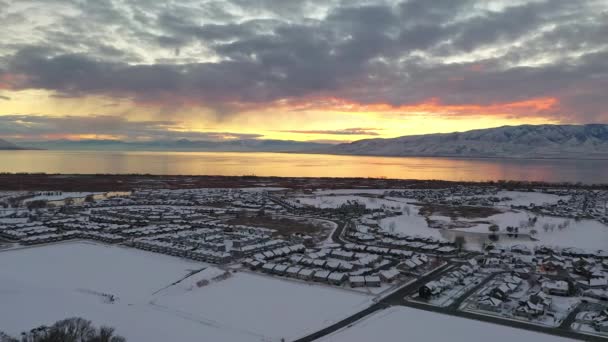 鸟在雪覆盖的城市景观上向后飞行 在五颜六色的日落对犹他州湖的方向 第3部分 — 图库视频影像