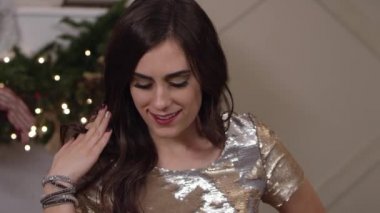 Bir bayram partisinde gülümseyen ve gösteriş yapan bir kadın, el kamerasını kapatır.