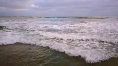 Dalgaların üzerinde yavaşça okyanusa doğru uçuyor.
