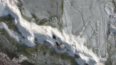 Shoreline aşağı bakıyor ve çubuktaki bir göl kenarındaki Buz yığınları üzerine Aeril görünümü.