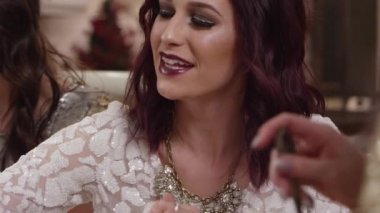 Tatil partisinde tatlı yerken arkadaşlarıyla konuşan ve gülen bir kadın.