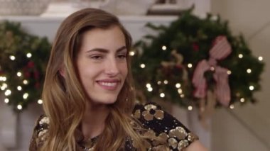 Bir tatil partisinde poz veren ve gülümseyen güzel bir kadının yakın çekim, el