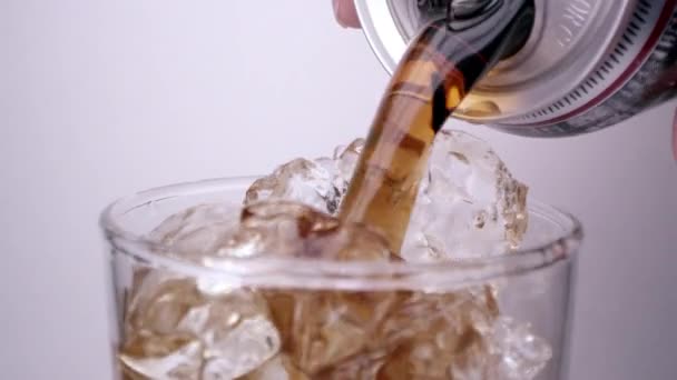 Cola verser dans le verre plein de glace comme il vibre tandis que le tir est tiré loin .