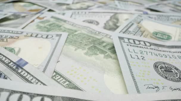 Se déplacer sur pile de billets de 100 dollars de près comme ils sont dispersés sur le dessus de la table .