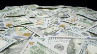 Masa üzerinde 100 dolar faturaları dağınık yığını üzerinde hareket.