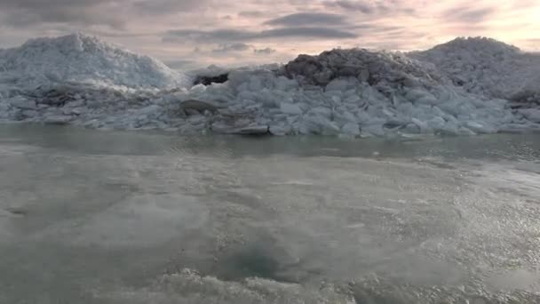 Voler à basse altitude au-dessus du rivage et au-dessus des piles de glace pour révéler le lac dans tout le paysage .