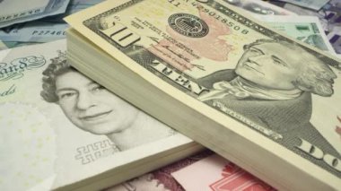 Dünya çapında para yığını üzerinde beş pound fatura için 10 dolarlık USD faturası üzerinde kaydırma.