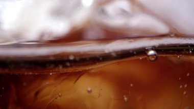 Makro görünümü kabarcıklar ve buz cam içecek kola olarak yavaş yavaş fizzes.