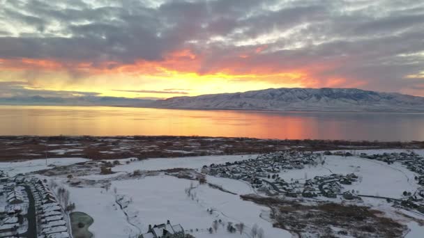 Flysikt Snødekte Urbane Bylandskap Fargerik Solnedgang Mot Utah Lake Del – stockvideo