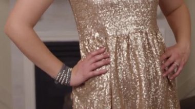 Tatil partisinde parıltılı bir elbisenin içinde gülümseyen bir kadın.