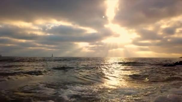 在五颜六色的沙滩上 在地平线上观赏帆船 在波涛汹涌的海浪上向后飞行 — 图库视频影像