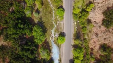 Nehir dere aşağı akar gibi kanyon da yol ve kaplıca yukarıdan aşağıya görünümü.