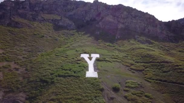 丘の中腹から山を下って飛んでいくY山のYの航空写真 — ストック動画