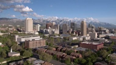 Salt Lake City şehir merkezine doğru uçan karla kaplı dağlara karşı silueti görüntüleme.