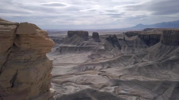 ユタ州の曇りの日に広いオープンビスタで砂漠の風景の上に岩を越えて飛んで — ストック動画