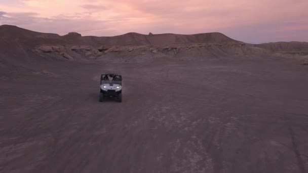 Ohv はユタ州の砂漠で日没時に後方に飛んでいる間砂漠の丘の上で駆動 — ストック動画