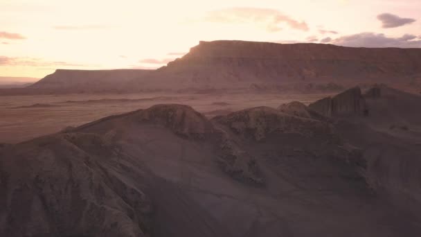 ユタ州スイングアームシティの遠くにモーターシルの人々と夕暮れに砂丘の上を飛ぶ — ストック動画