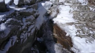 Havadaki su akmasını takiben kışın şelale üzerinde uçan havadan görünüm.