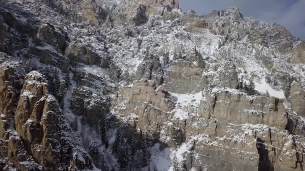 在阳光平移的鸟图下 被雪覆盖的岩石悬崖亮起 — 图库视频影像