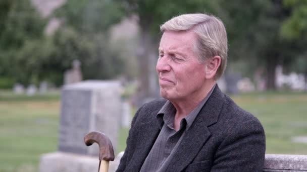Elderly Man Sitting Cemetery Fidgets His Cane Being Lost Thought — Stock Video