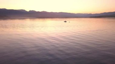 Utah, Abd - Circa 2017: Renkli gün batımı sırasında gölün üzerinde tekneye doğru uçmak teknenin yanındaki tüplerde oturan insanları görüntüler.