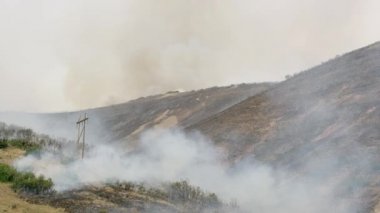 Helikopter bir kova suyla uçarken yamaçta yangın çıktı..