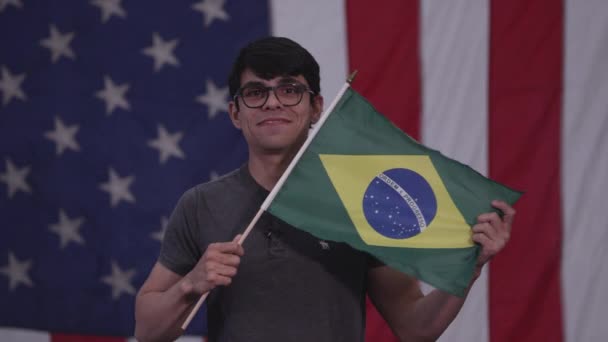 Людина Тримає Прапор Бразилії Він Стоїть Перед Американським Прапором — стокове відео