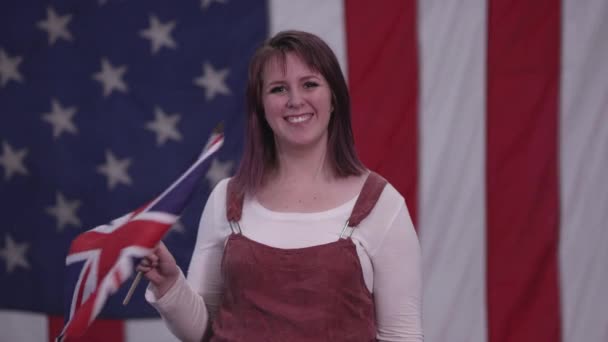 Mujer Ondeando Bandera Union Jack Mientras Sonríe Pie Frente Bandera — Vídeo de stock