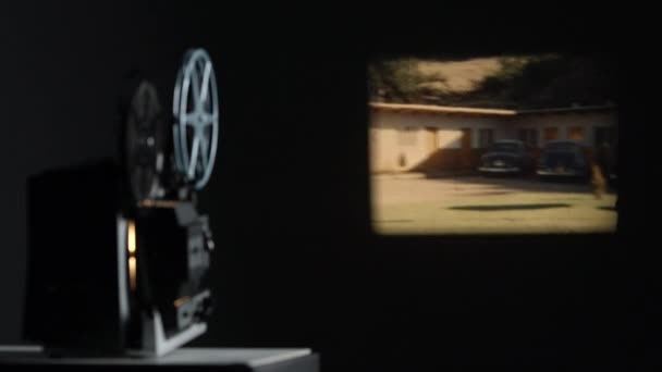 1960年代の古い車やモーテルを示す古いフィルムを再生壁に投影されたフィルム — ストック動画
